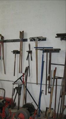 Lot -- shovels, post hole digger, pick, brooms, etc on wall *** PLEASE NOTE: This lot is offered subject to bulk bid offer on lot 118 - 2